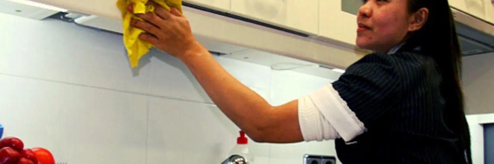 Trabajadora de casas particulares limpiando una cocina